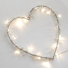 a heart - shaped string of lights is shown on a white surface with small stars