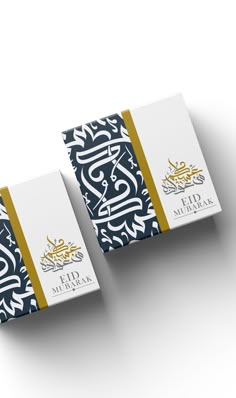 two boxes with arabic writing on them sitting next to each other in front of a white background