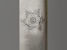 a white paper towel with an ornamental design on it and a black circle in the middle