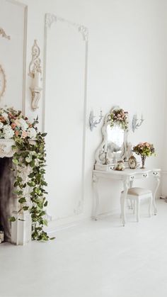 a white room with flowers and mirrors on the wall