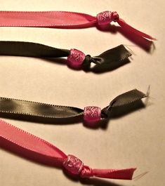 three pink and black hair ties laying on top of each other