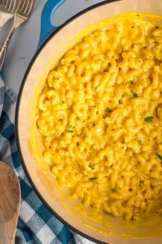 a large pot filled with macaroni and cheese on top of a blue towel