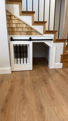 a dog house built into the side of a stair case with its door open to let it in