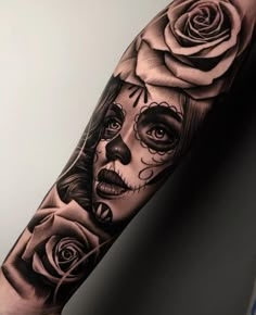 a woman's arm with roses on it and a skull in the middle is shown