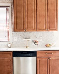 a kitchen with wooden cabinets and white counter tops, along with a dishwasher