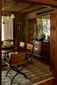 a dining room table with chairs and a bowl of fruit on it