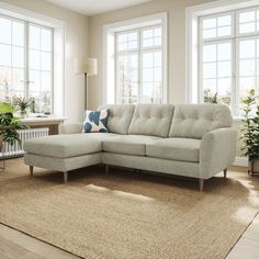 a living room scene with focus on the corner sofa and rug, along with two large windows