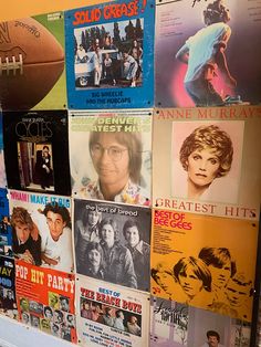 a bunch of posters on the side of a wall with footballs and women's magazines