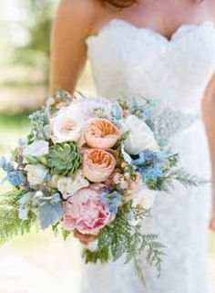 a bridal holding a bouquet of flowers and greenery