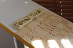 a toy model of a hot dog on a table with sun shining through the blinds