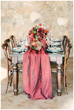 the table is set with flowers, candles and napkins for an elegant dinner party