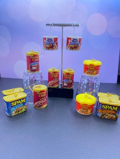 several containers of food are sitting on a table next to a stand with five cans