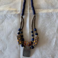 Handmade Necklace By Santa Fe Artist Terry Hawn. The Necklace Is 17" Long And Made Of Antique African Trade Beads With An Antique Silver Afghani Pendant. Unique Blue Wooden Beads, Artisan Blue Wooden Beads, Blue Wooden Beads, Traditional Blue Jewelry With Wooden Beads, Unique Blue Wooden Beaded Necklaces, Blue Wooden Beads For Jewelry Making, Adjustable Blue Necklace With Wooden Beads, Yellow Jewelry With Silver Beads For Gift, Blue Wooden Beads Jewelry For Jewelry Making