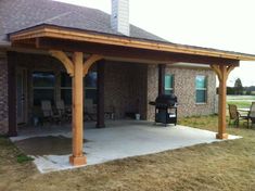 a covered patio with chairs and an outdoor grill