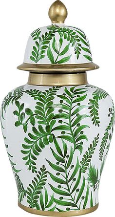 a white vase with green leaves painted on the front and gold trimming around it