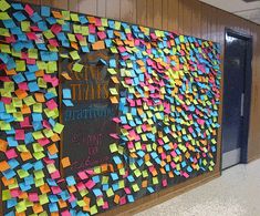 a bulletin board with post it notes attached to the wall and writing on the back