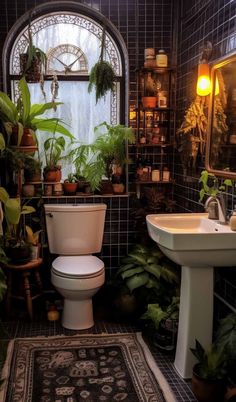 a bathroom with a toilet, sink and potted plants