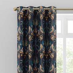 the curtain is hanging in front of a window with an ornate pattern on it,