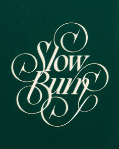 the words slow burn are written in cursive type on a dark green background