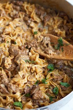 a pot full of pasta with meat and parsley