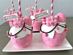 there are some pink and white cakes with bows on them, one is shaped like a basket