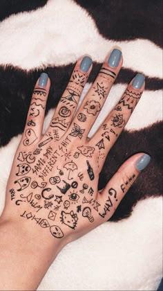 a woman's hand with many tattoos on it