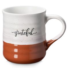 a white and orange coffee mug with the word grateful written on it's side