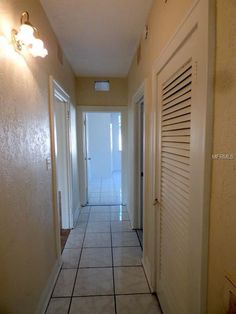 an empty hallway leading to two doors and another door is open on the other side