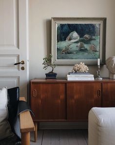 a living room with a painting on the wall