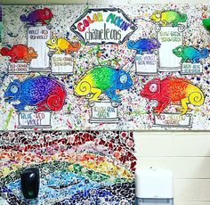 a wall with many different colored fish on it and a sign that says chameleons