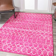 a bright pink rug with white designs on the front and back ends, in an entryway