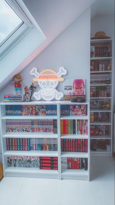 a book shelf filled with lots of books next to a skylight in a room