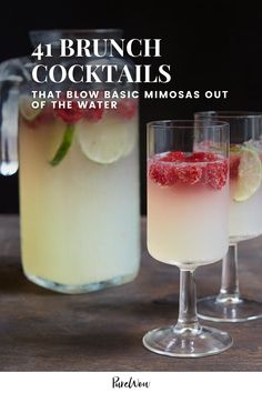 two glasses filled with drinks sitting on top of a wooden table