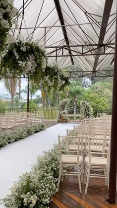 an outdoor wedding venue with white chairs and flowers