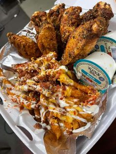 fried chicken and other food items on a paper plate with milk in a container next to it