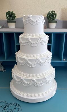 a large white wedding cake sitting on top of a blue table