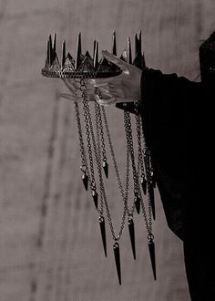 black and white photograph of a woman holding a tray with spikes on it's sides