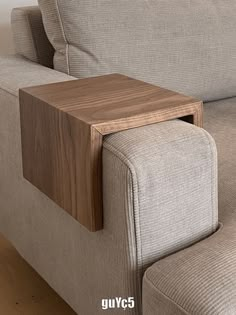 a close up of a couch with a wooden table on it's back end