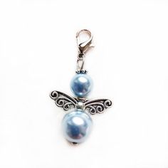 two blue pearls are attached to a silver charm