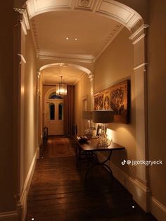 a long hallway with an archway leading to another room on one side and a lamp on the other