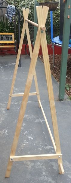 a wooden easel sitting on top of a cement ground