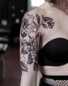 a woman wearing a bra with flowers on her arm