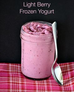 a pink smoothie in a mason jar next to a spoon