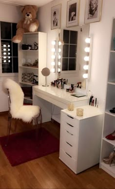 a white vanity with lights and a teddy bear