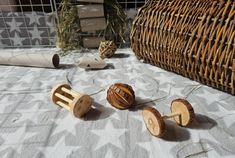 three wooden toys sitting on top of a table next to a basket and toilet paper