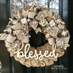 a burlock wreath with the word,'blessed'is hanging on a door