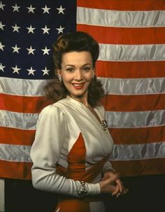 a woman standing in front of an american flag