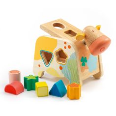 a wooden toy cow with colorful shapes and colors