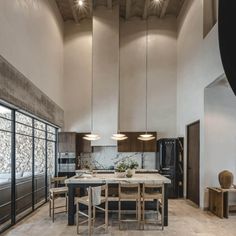 a large kitchen with an island table surrounded by chairs