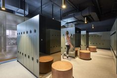 a man standing in front of lockers with bicycles on them and lights hanging from the ceiling